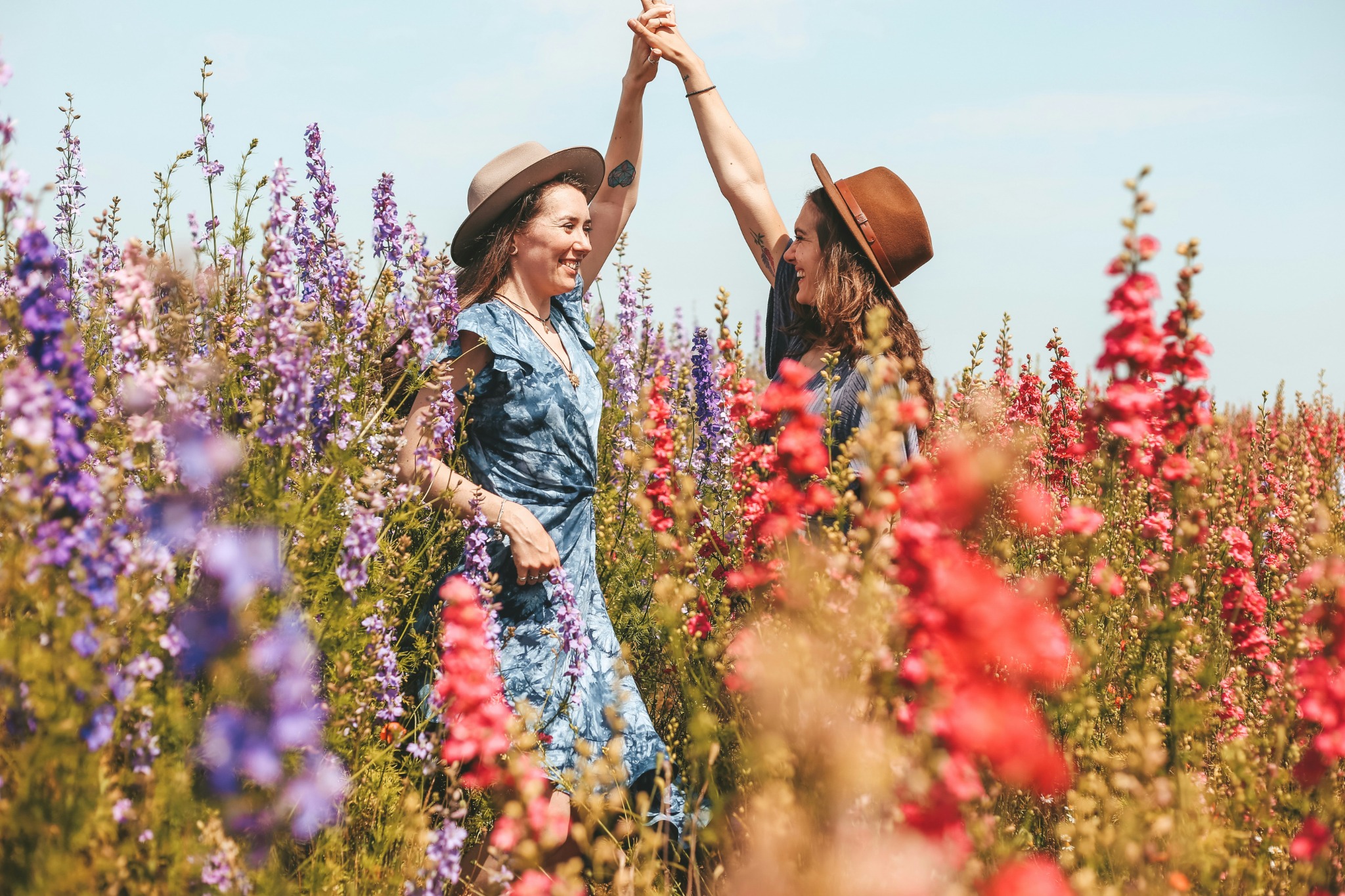 Dos mujeres con sombrero entre flores